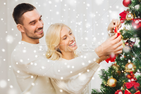 happy couple decorating christmas tree at home Stock photo © dolgachov