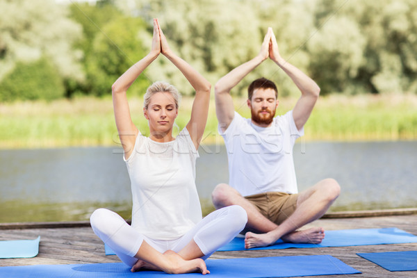 people meditating in yoga lotus pose outdoors Stock photo © dolgachov