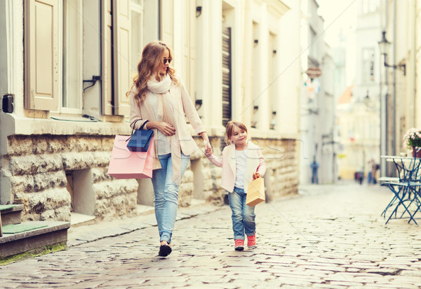 happy mother and child with shopping bags in city Stock photo © dolgachov