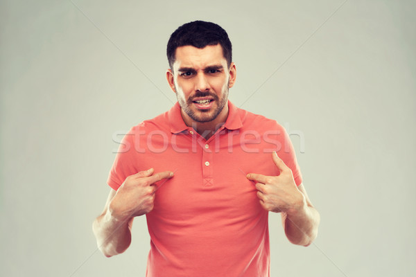 angry man pointing finger to himself over gray Stock photo © dolgachov