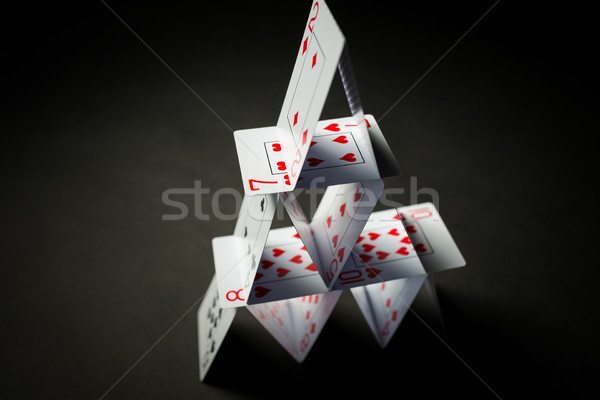 Stock photo: house of playing cards over black background
