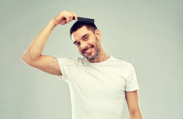 happy man brushing hair with comb over gray Stock photo © dolgachov