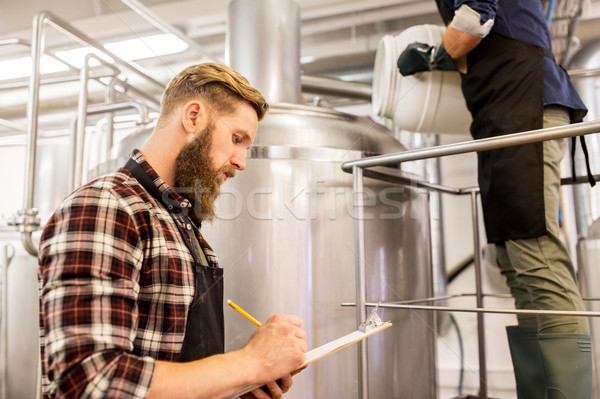 men working at craft brewery or beer plant Stock photo © dolgachov