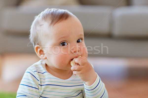 Stock photo: baby boy eating rice cracker at home