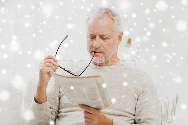 senior man in glasses reading newspaper at home Stock photo © dolgachov