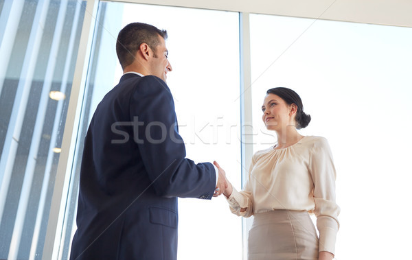 smiling business people shaking hands at office Stock photo © dolgachov