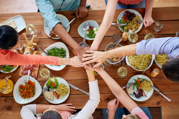 people holding hands together over table with food Stock photo © dolgachov