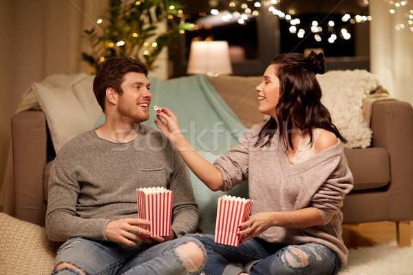 happy couple eating popcorn at home Stock photo © dolgachov