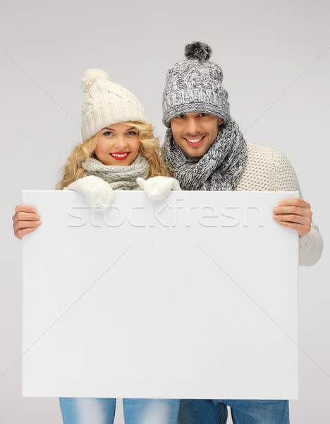 couple in a winter clothes holding blank board Stock photo © dolgachov