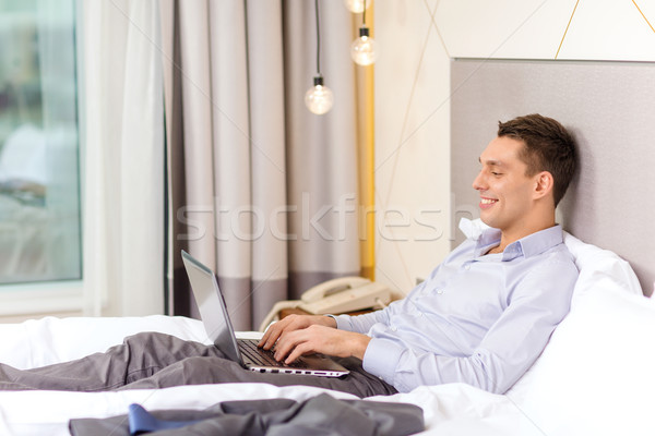 happy businesswoman with laptop in hotel room Stock photo © dolgachov