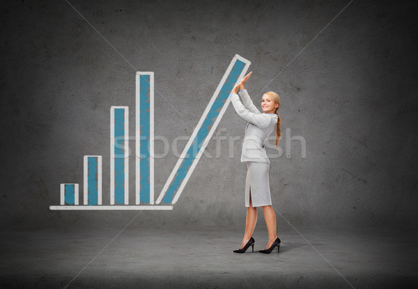 young smiling businesswoman pushing up chart bar Stock photo © dolgachov
