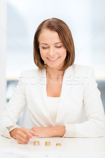Stock photo: businesswoman putting euro coins into columns