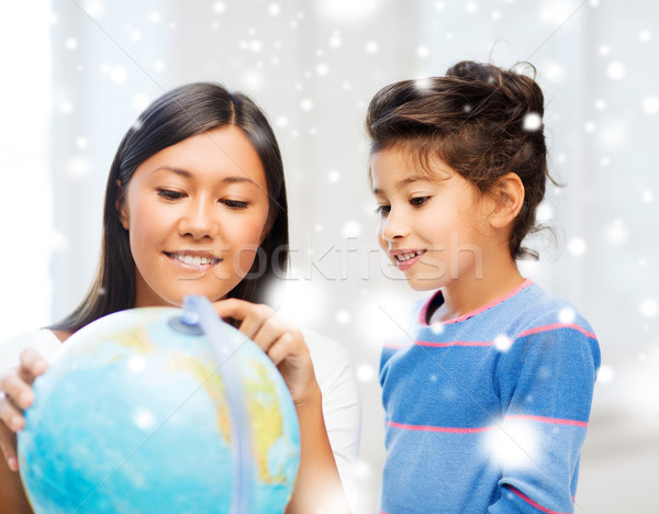 mother and daughter with globe indoors Stock photo © dolgachov