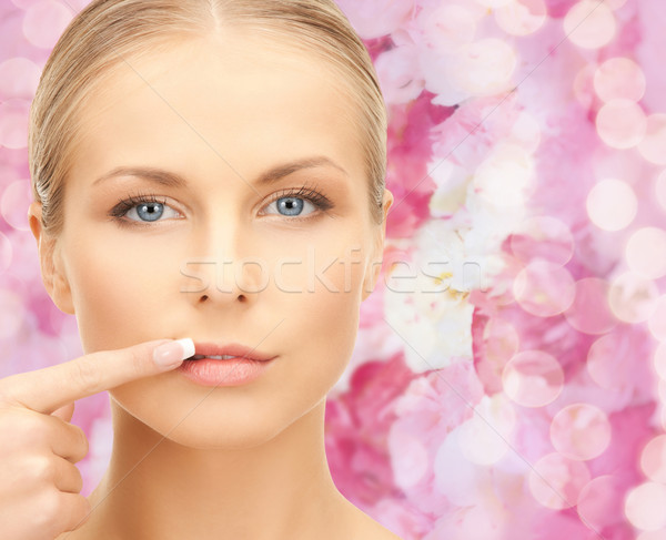 beautiful young woman pointing finger to her lips Stock photo © dolgachov