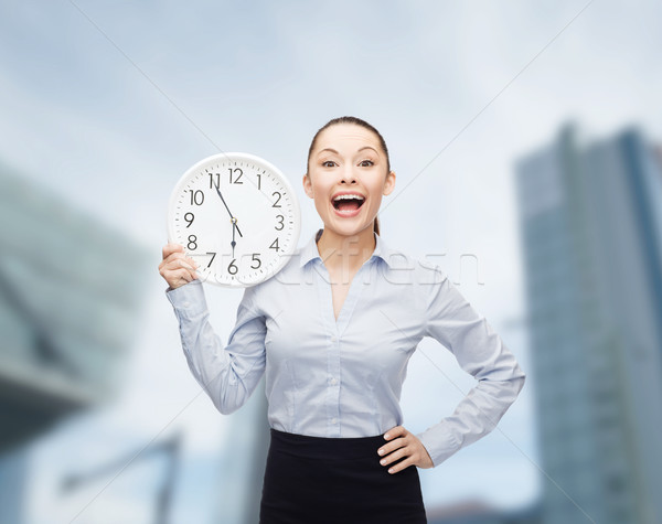 attractive businesswoman with wall clock Stock photo © dolgachov