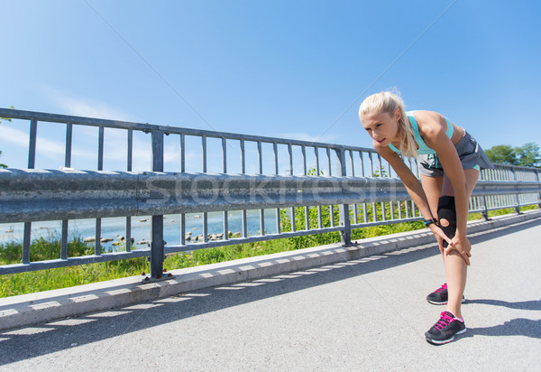 young woman with injured knee or leg outdoors Stock photo © dolgachov