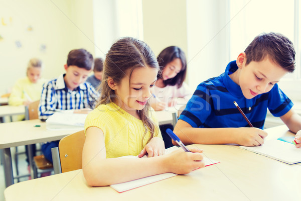 Stock photo: group of school kids writing test in classroom