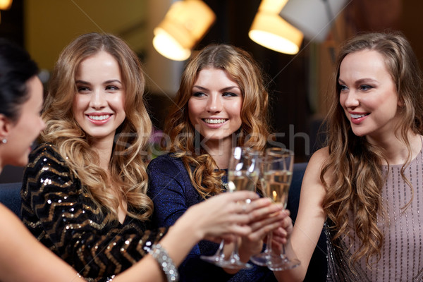 happy women with champagne glasses at night club Stock photo © dolgachov