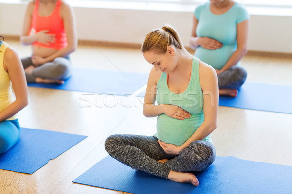 happy pregnant women exercising yoga in gym Stock photo © dolgachov