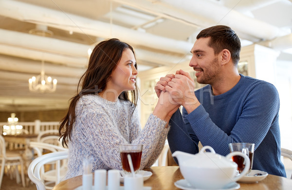 Feliz Pareja té tomados de las manos restaurante personas Foto stock © dolgachov