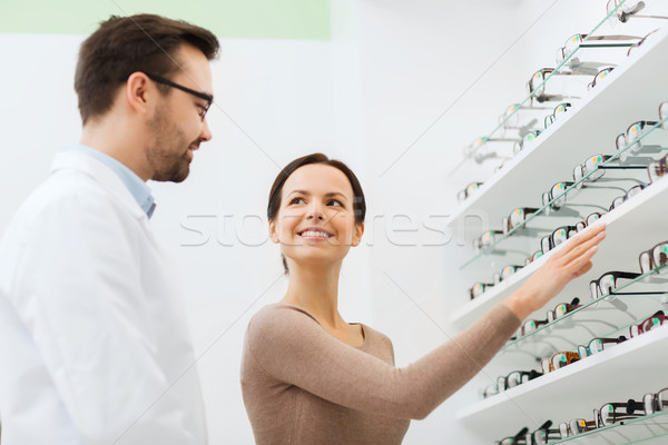 woman showing glasses to optician at optics store Stock photo © dolgachov
