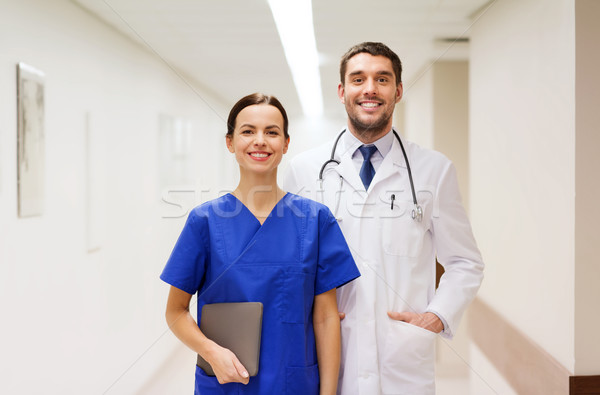 smiling doctor in white coat and nurse at hospital Stock photo © dolgachov