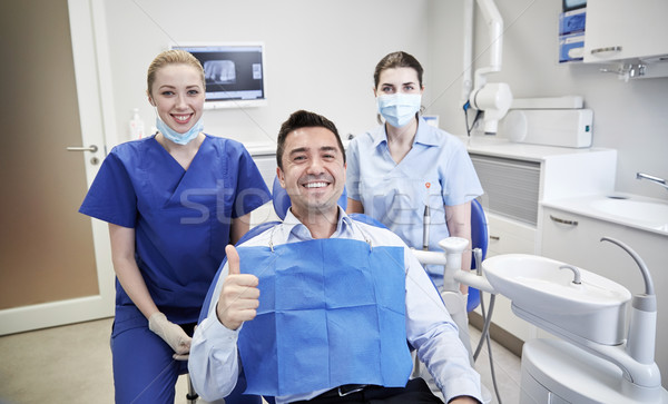Fericit femeie stomatologi om pacient clinică Imagine de stoc © dolgachov