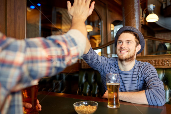 happy male friends making high five at bar or pub Stock photo © dolgachov