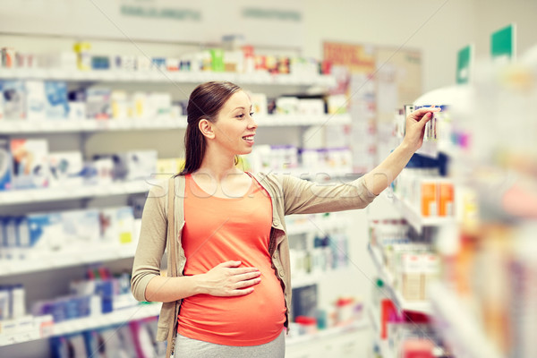 happy pregnant woman choosing medicine at pharmacy Stock photo © dolgachov