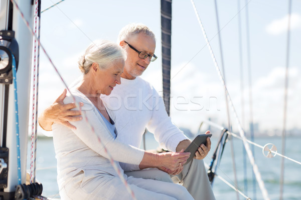 Stock photo: senior couple with tablet pc on sail boat or yacht
