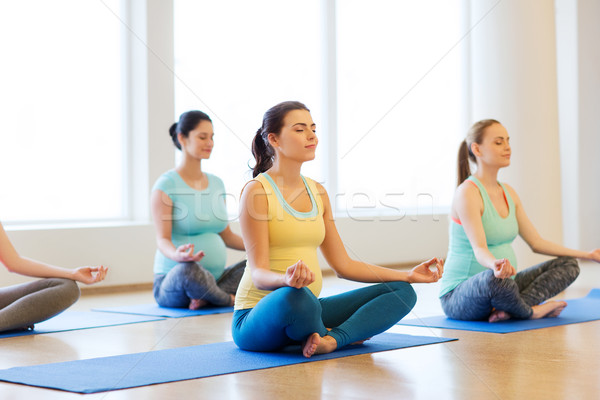 happy pregnant women exercising yoga in gym Stock photo © dolgachov