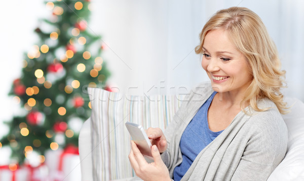 smiling woman with smartphone texting at home Stock photo © dolgachov