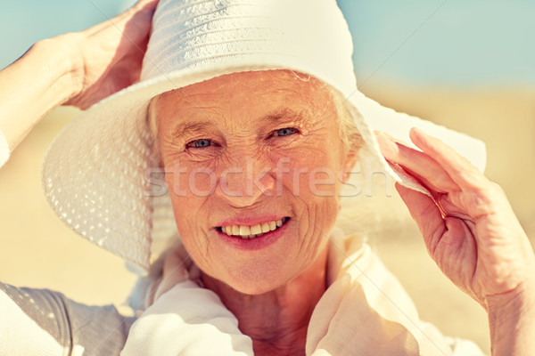 happy senior woman in sun hat on summer beach Stock photo © dolgachov