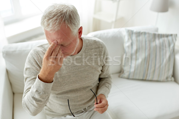 senior man suffering from headache at home Stock photo © dolgachov