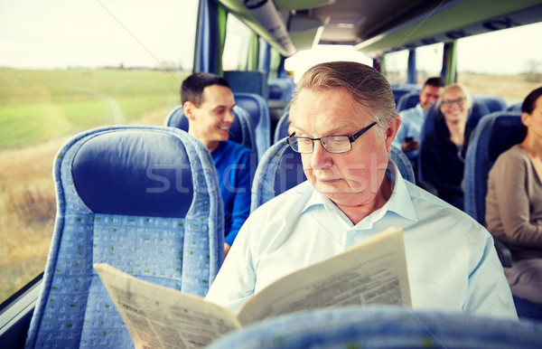 happy senior man reading newspaper in travel bus Stock photo © dolgachov