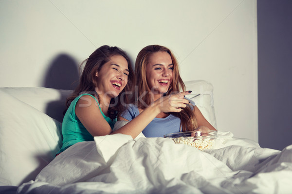 Fericit prietenii floricele de porumb vizionarea televizor acasă Imagine de stoc © dolgachov