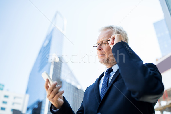 senior businessman with smartphone in city Stock photo © dolgachov
