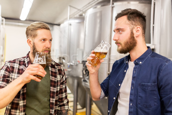 men drinking and testing craft beer at brewery Stock photo © dolgachov