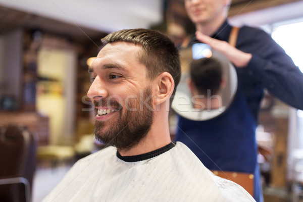 man and hairdresser with mirror at barbershop Stock photo © dolgachov