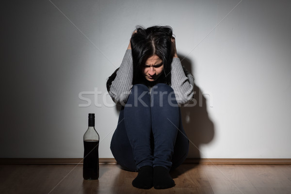 woman with bottle of alcohol crying at home Stock photo © dolgachov