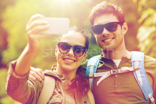 couple with backpacks taking selfie by smartphone Stock photo © dolgachov