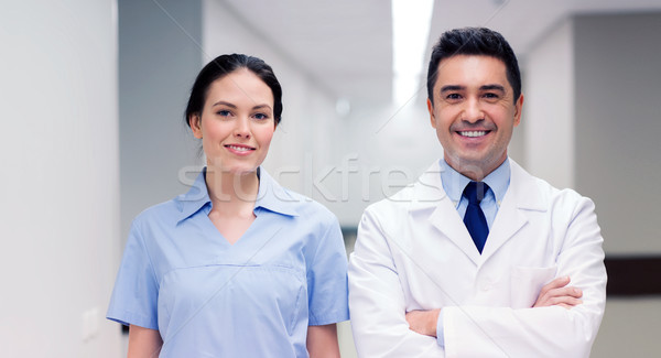 Stock photo: smiling doctor in white coat and nurse at hospital