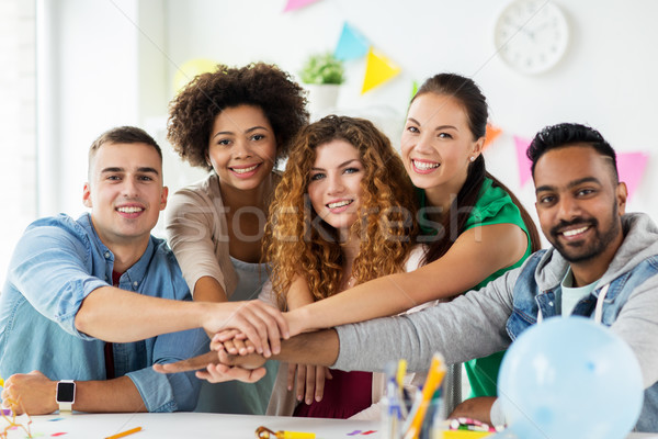 happy team at office party holding hands together Stock photo © dolgachov