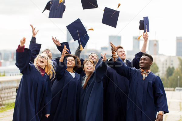 happy graduates or students throwing mortar boards Stock photo © dolgachov
