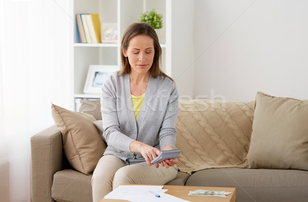 woman with money, papers and calculator at home Stock photo © dolgachov