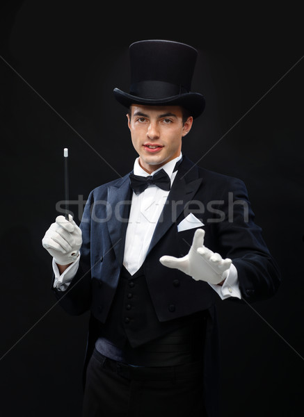 magician in top hat with magic wand showing trick Stock photo © dolgachov