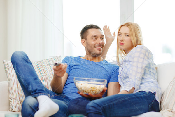 Stock photo: smiling couple with popcorn choosing what to watch