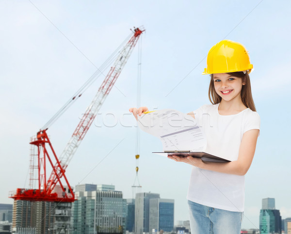 Sonriendo nina casco de seguridad portapapeles infancia construcción Foto stock © dolgachov