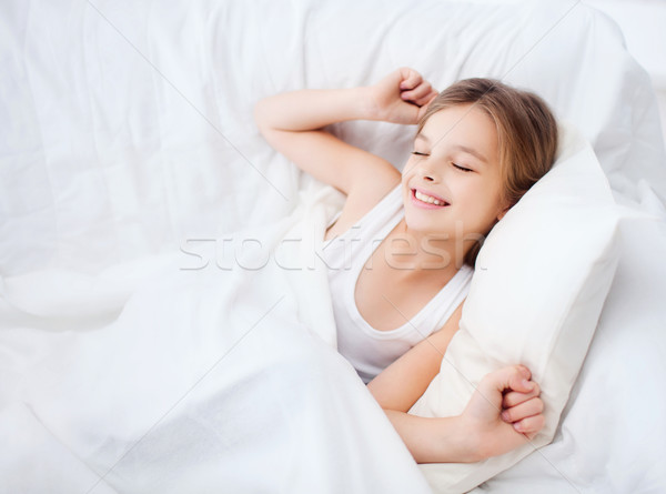 smiling girl child waking up in bed at home Stock photo © dolgachov