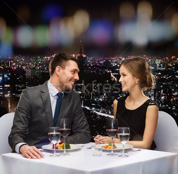smiling couple eating main course at restaurant Stock photo © dolgachov